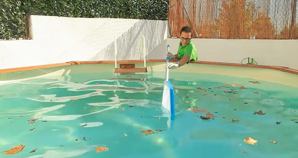 Un usuario limpia una piscina privada